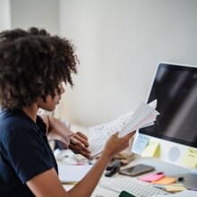 A person organizing paperwork at a desk